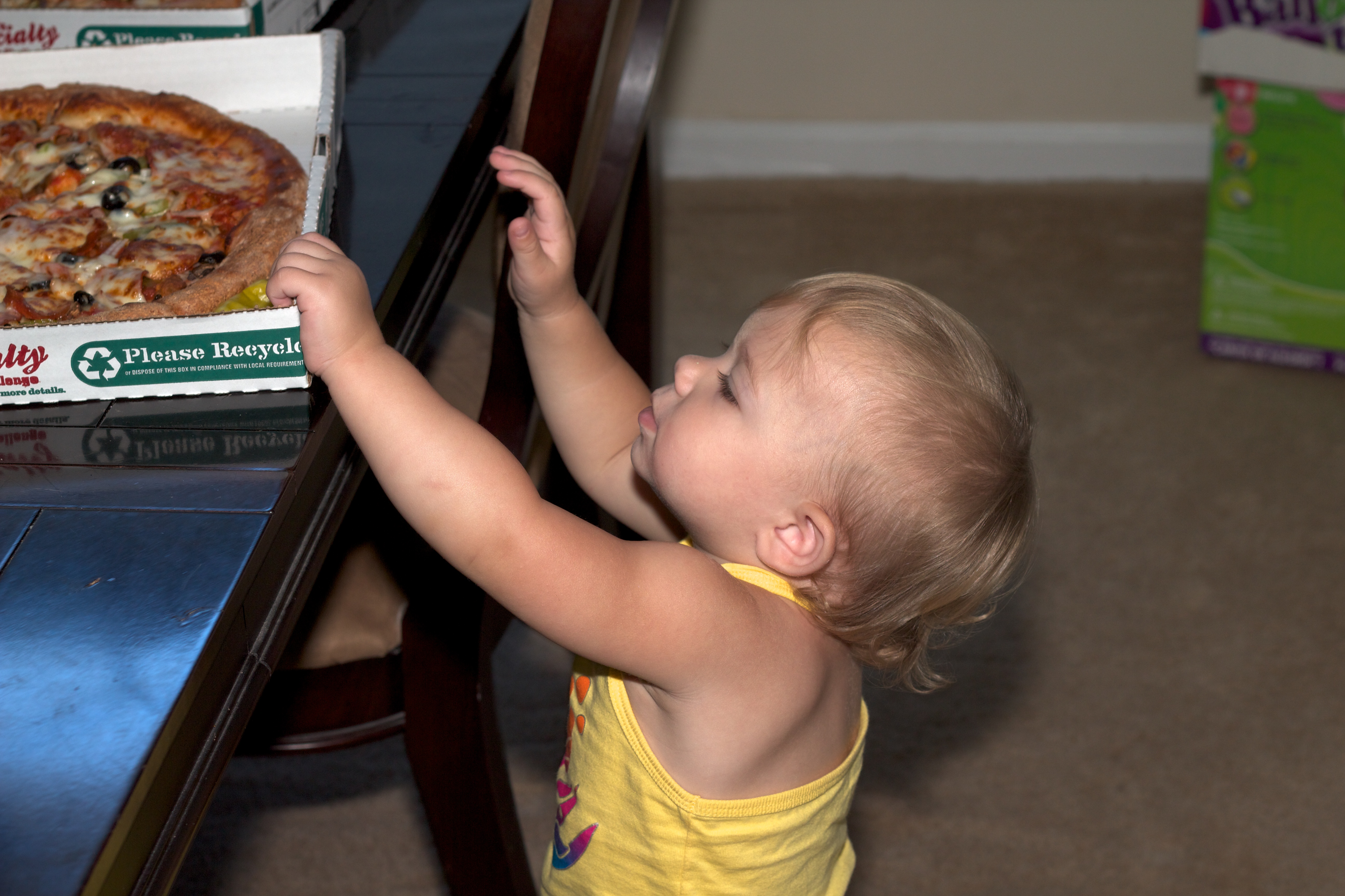 Toddler reaching for the pizza box